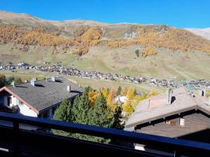 Vistas a una casa con montañas en el fondo en Appartamenti - Formula Roulette en Livigno