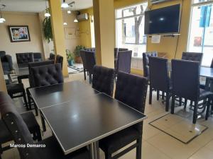 Sala de conferencias con mesas, sillas y TV en Hotel Avenida en La Rioja