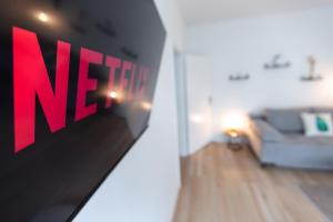 a netflix sign in a living room with a couch at Koje Sechs I Apartment im Zentrum mit Hafenblick in Bremerhaven