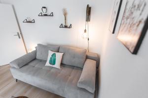 a living room with a gray couch in a room at Koje Sechs I Apartment im Zentrum mit Hafenblick in Bremerhaven +20 photos