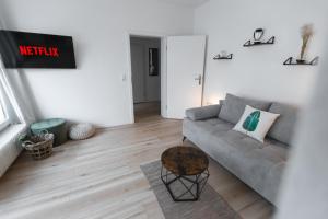 a living room with a couch and a table at Koje Sechs I Apartment im Zentrum mit Hafenblick in Bremerhaven