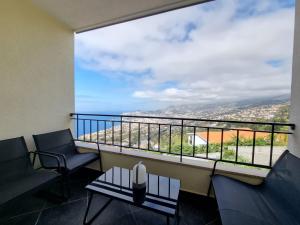 a balcony with two chairs and a large window at Olimpia Gardens View by Rentallido in São Gonçalo