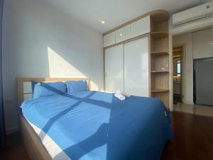 - une chambre avec un lit bleu et une couette bleue dans l'établissement D'CAPTIALE TRAN DUY HUNG, à Hanoï