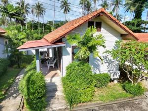 a cottage with a table and a chair at Bluewhale Home Samui in Amphoe Koksamui