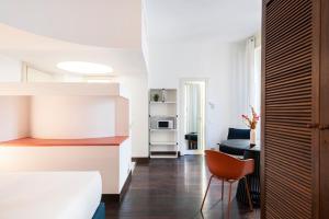 sypialnia z łóżkiem i krzesłem w pokoju w obiekcie RELSTAY - Montenapoleone Suite w Mediolanie