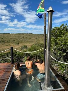 un gruppo di 3 persone in una piscina di Ostrich cottage at Les Wings private game farm a Jongensfontein