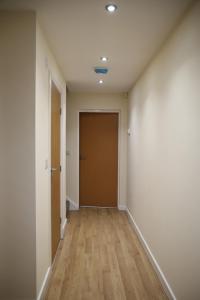 un corridoio vuoto con porta e pavimenti in legno di Douglas's House a Dublino