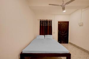 Bett in einem Zimmer mit Deckenventilator in der Unterkunft SPOT ON Hotel Paradise Inn in Nowgong