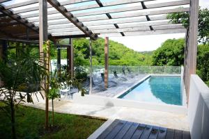 a house with a swimming pool and a pergola at Villa Noucinq in Le Gosier