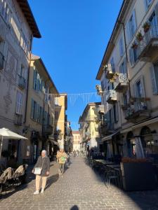 a group of people walking down a street with buildings at La Porta Azzurra - Casa Vacanze in Como