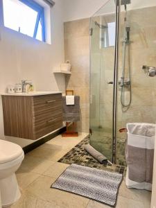 a bathroom with a shower and a toilet and a sink at Kozy Korner Apartment in Baie du Tombeau