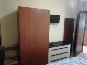 a bedroom with a large wooden cabinet next to a bed at HOTEL GIORDANA in Loano