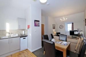 a kitchen and dining room with a table and a kitchen and a living room at Douglas House Apartments in Nairn