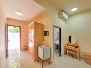 a room with a small refrigerator and a mirror at Sunrise Inn in Thoddoo