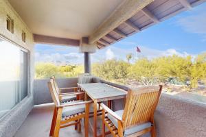 eine Veranda mit einem Tisch und Stühlen auf dem Balkon in der Unterkunft Vistoso Resort Casita #207 in Tortolita