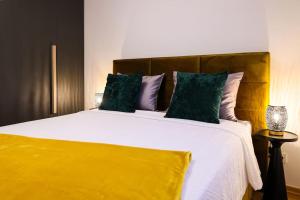 sypialnia z dużym białym łóżkiem z zielonymi poduszkami w obiekcie Luxury Infusion by HOME Apartments - Free Parking w Zagrzebiu
