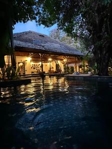 a house with a pool of water at night at My Secret Home in Seminyak