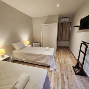 um quarto de hotel com duas camas e uma televisão em CASA IMPERIAL HOTEL POUSADA em São Luís