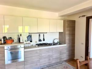 a kitchen with white cabinets and a sink at Casa vacanze Borgo Rondini in Rocca di Cambio