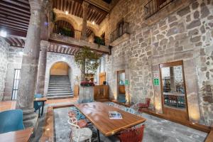 Habitación con mesa y pared de piedra. en OYO Hostal Mich en Morelia
