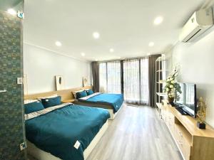 a bedroom with two beds and a flat screen tv at Old town Duplex 3 Double beds & 2 big balcony in Hanoi