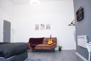 a bedroom with a couch with a guitar on it at Central Blissful Haven in Liverpool