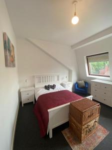 - une chambre avec un lit blanc et une couverture rouge dans l'établissement Impeccable 1-Bed Apartment in Putney Village, à Londres