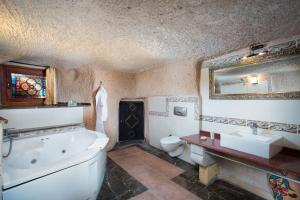 a bathroom with a tub and a toilet and a sink at Cappadocia Fairy Chimneys Selfie Cave Hotels - Special Class in Uchisar