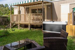 einen Hinterhof mit einem Whirlpool und einer Terrasse in der Unterkunft Camping du Château Vert in Hondainville