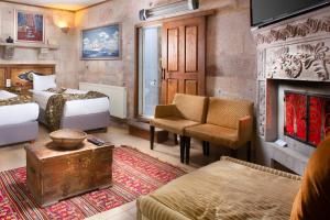 - une chambre d'hôtel avec 2 lits et une cheminée dans l'établissement Cappadocia Fairy Chimneys Selfie Cave Hotels - Special Class, à Uçhisar