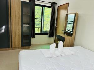 um quarto com uma cama com duas toalhas em La Villas@Suanphueng em Ban Bo Wi