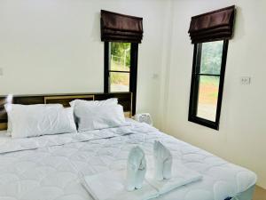 um quarto com uma cama com um par de sapatos em La Villas@Suanphueng em Ban Bo Wi