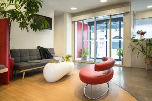 a living room with a couch and a red and white stool at ibis Paris Gare de Lyon Reuilly in Paris