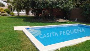 a swimming pool in the grass next to a house at La Casita de Cieneguilla in Cieneguilla