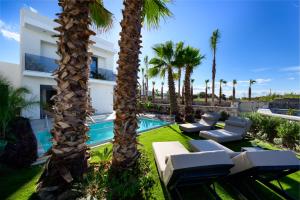 un resort con palme e piscina di Penélope Beachfront Villa a Kremasti
