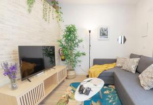 Artistic Digital Getaway Large 1 Bedroom King Bed - Great Location في فالنسيا: غرفة معيشة مع أريكة ومدفأة