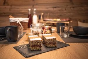 une assiette avec trois morceaux de gâteau sur une table dans l'établissement Chalet Berg, à Selva dei Molini