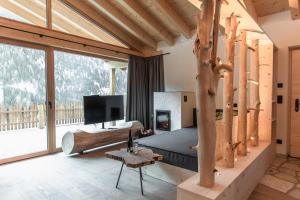a bedroom with a bed and a fireplace and a tv at Chalet Berg in Selva dei Molini