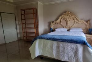 a bedroom with a large bed with a blue and white blanket at Sapphire Lodge in Stegi