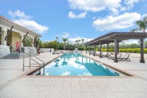 una piscina con bancos y un pabellón en 8537 - 4BR Disney World Vacation Townhome, en Orlando