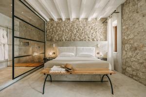 a bedroom with a bed and a stone wall at Susafa in Vallelunga Pratameno