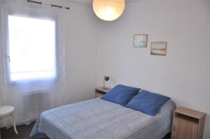 Un dormitorio con una cama azul y una ventana en Bel appartement 2 chambres au centre-ville de PERROS-GUIREC - Ref 926, en Perros-Guirec