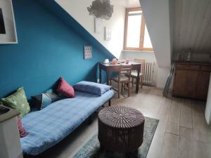 ein Wohnzimmer mit einem blauen Sofa und einem Tisch in der Unterkunft Mansarda nel centro di Torino in Turin