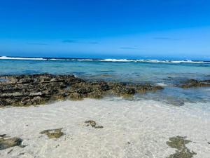 une plage avec des rochers et l'océan par temps clair dans l'établissement Bungalow TEIPO, à Teavaro