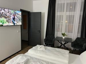 ein Hotelzimmer mit einem Bett und einem Flachbild-TV in der Unterkunft Hotel Elisei in Nürnberg