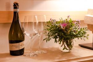 マントヴァにあるCasa dell'Architettoのワイン1本とワイングラス2杯(テーブル上)