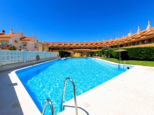 a large blue swimming pool with a building in the background at Casa del Sol in Salobreña
