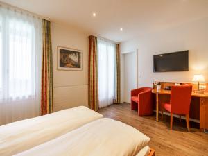 a hotel room with a bed and a desk at Hotel Seeburg - Adults only in Ringgenberg