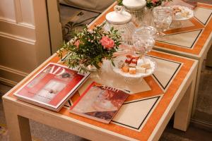 un tavolo con riviste e fiori sopra di Casa dell'Architetto a Mantova