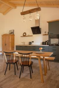 una cucina con tavolo in legno e 2 sedie di Ferienwohnung Zum Lenei a Staudach-Egerndach